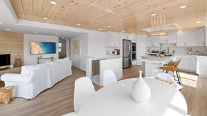 Een moderne keuken met witte kasten, een centraal eiland en een roestvrijstalen koelkast.