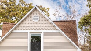 A two-story house with a front porch, a chimney, and a mailbox. - Beautiful House | Walk Everywhere | AC| Fire Pit | (Traverse City)