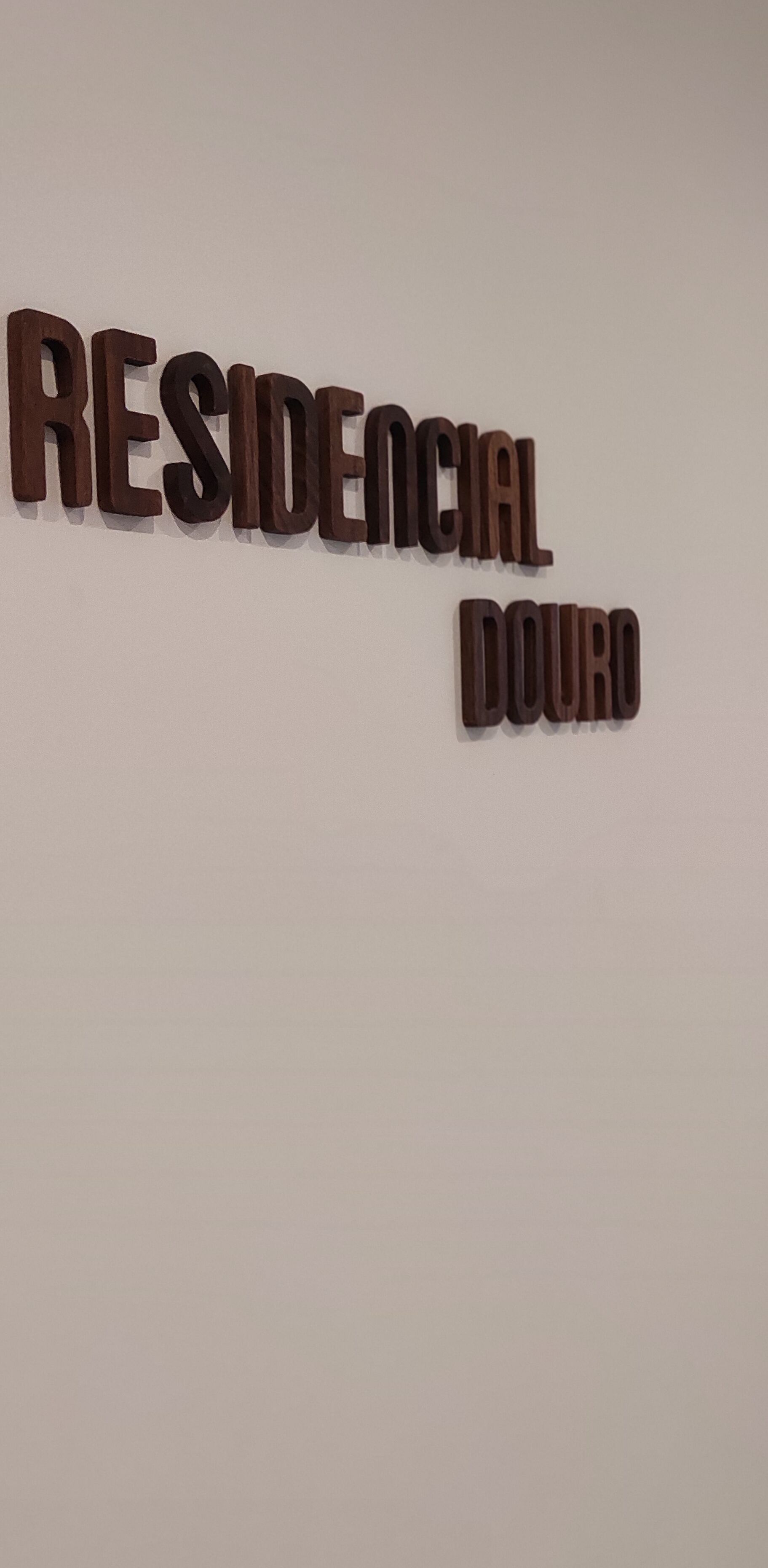 A wall with the words "RESIDENCIAL DOURO" in wooden letters.