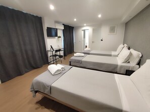 A hotel room with two beds, a desk, a chair, and a TV. - Residencial Douro (Peso da Régua)