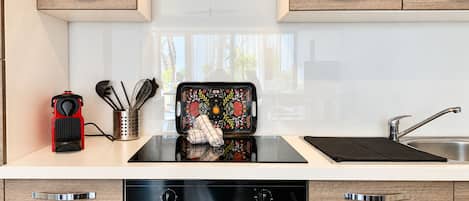 Una cocina moderna con horno empotrado, pileta de acero inoxidable y muebles de madera.