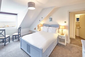 A bedroom with a large bed, two bedside tables, a chair, and a window with a view. - Host & Stay | The Whitby Pearl (Whitby)