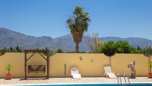 A pool area with a swing chair, a sun lounger, and a statue. - Casa Mari is a fabulous Villa with large swim pool, tennis,  Games Room, garden  (Turre)