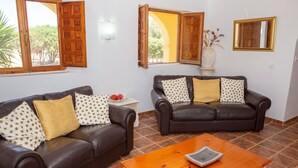 A living room with two brown leather sofas, a wooden coffee table, and a white side table with a vase. - Casa Mari is a fabulous Villa with large swim pool, tennis,  Games Room, garden  (Turre)