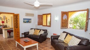 A living room with two leather sofas, a wooden coffee table, and a ceiling fan. - Casa Mari is a fabulous Villa with large swim pool, tennis,  Games Room, garden  (Turre)