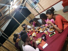 A group of people dining at a table with various dishes and drinks.