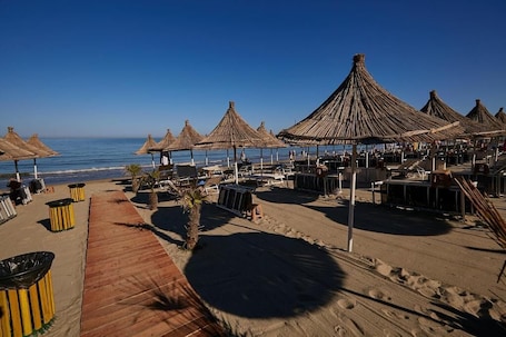 Playa privada, camas de playa, sillas reclinables de playa, sombrillas