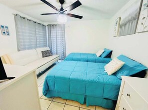 Cozy retreat with a single bed, sofa, and desk, perfect for a relaxing stay.