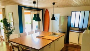 A modern kitchen with a wooden island, white cabinets, a built-in oven, and a refrigerator. - House not available (Tarnos)