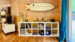 A room with a wooden wall, a surfboard, a bookshelf, and a window with curtains. - House not available (Tarnos)