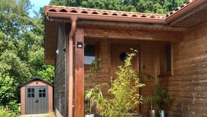 A wooden house with a porch, a small shed, and a staircase leading to the entrance. - House not available (Tarnos)