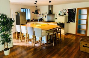 A modern kitchen with a central island, wooden flooring, and a potted plant. - House not available (Tarnos)