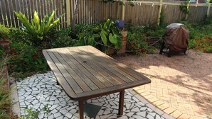 Eine Terrasse mit einem Holztisch und einem Mosaikboden.