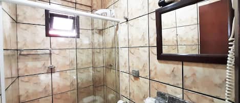 Un baño con cabina de ducha revestida de mármol, un secador de manos, un perchero y un espejo.