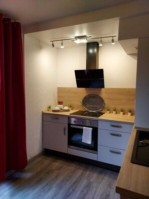 Una cocina moderna con horno empotrado, microondas y campana extractora.