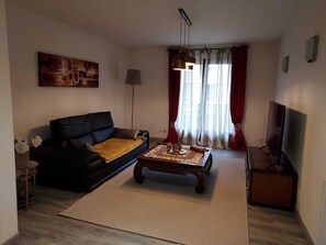 A living room with a sofa, coffee table, and a TV.