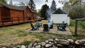 Un chalet rustique doté d’une terrasse en bois et d’un espace salon extérieur.