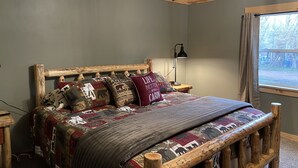 Une chambre à coucher avec une tête de lit en bois, une couvre-lit matelassée et une table de chevet avec une lampe.
