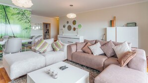 Ein modernes Wohnzimmer mit einer Couch, einem Couchtisch und dekorativen Spiegeln.