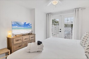 Relax in a spacious room with a large bed, TV, and stunning beach views.