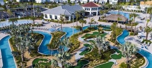 Ein Resort mit mehreren Schwimmbecken, Palmen und einem zentralen Gebäude mit rotem Dach.