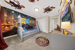 A bedroom with a bed, a wall mural, a round rug, and a lamp. - 2929 SS - Disney Delight: 4BR, Pool, Near Parks (Kissimmee)