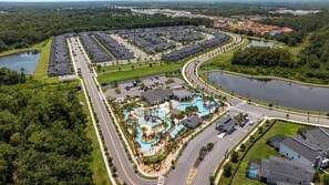A residential area with a swimming pool, roads, and surrounding greenery. - 2929 SS - Disney Delight: 4BR, Pool, Near Parks (Kissimmee)
