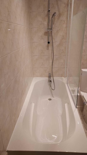 Banheira, secador de cabelo, toalhas de banho, papel higiênico