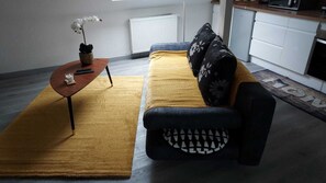 Una sala de estar moderna con un sofá, una mesita de centro y una planta en maceta.