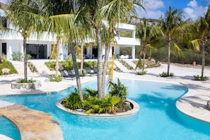 Una piscina al aire libre, camas de piscina gratis, sombrillas