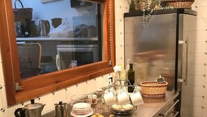 Una cuina amb taulell d'acer inoxidable, una finestra i un frigorífic.
