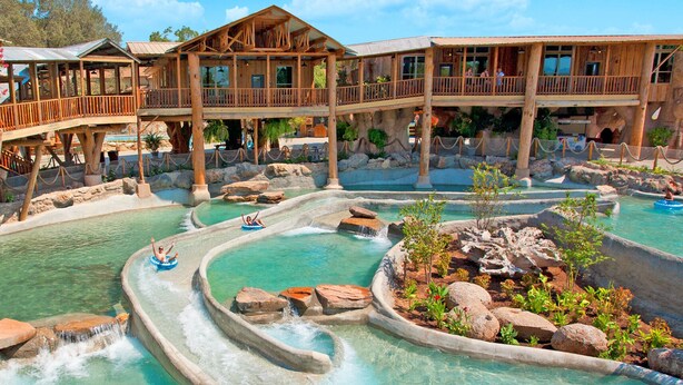 A resort with a water park, wooden cabins, and a pool area.