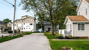 A residential street with houses, a sidewalk, and a grassy area. - The Lilly Pad • Charming 1BR • Walk to Sylvan Beach (Sylvan Beach)