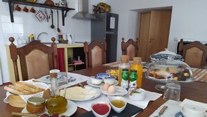A dining table set with various food items, including bread, eggs, and a glass dish with pastries. - Casa D'Augusta Agrotourism (Miranda do Douro)
