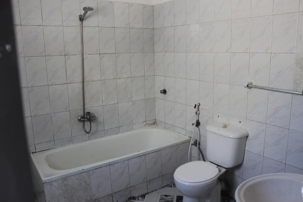 Um banheiro com banheira, vaso sanitário e chuveiro.