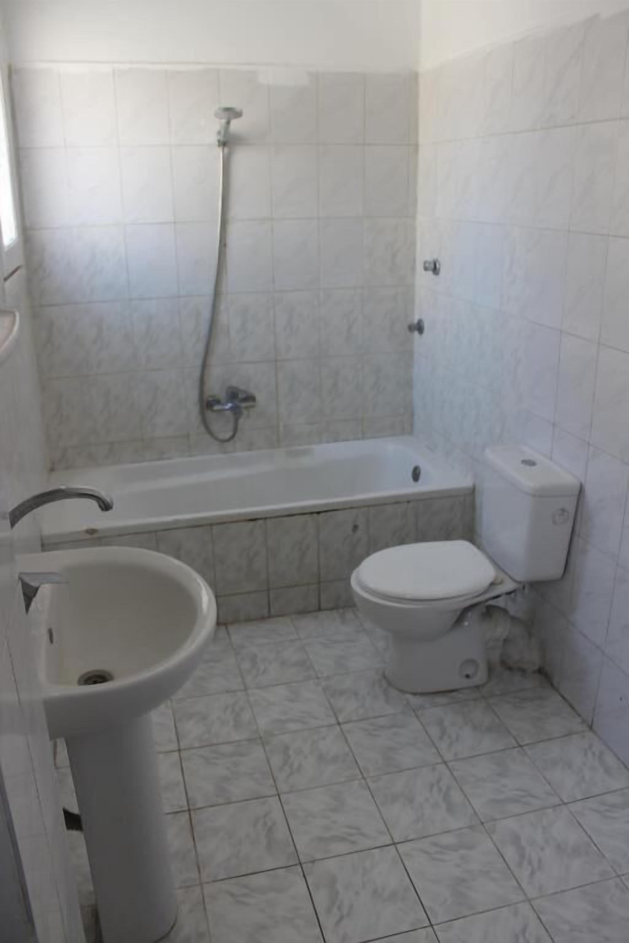 A bathroom with a bathtub, toilet, and sink.
