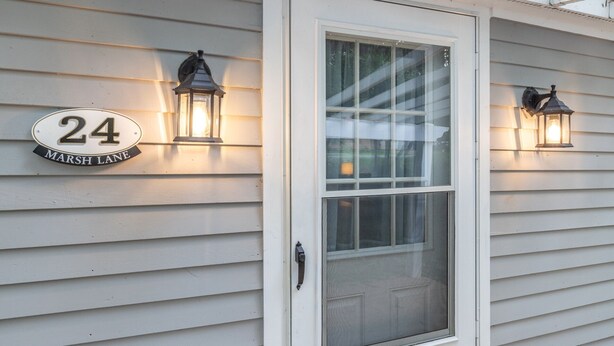 A house number 24 with a sign that reads "Marsh Lane" and two wall-mounted lantern-style lights. - Causeway Cottage: Lake Beach & NY Biking Ferry (Colchester)