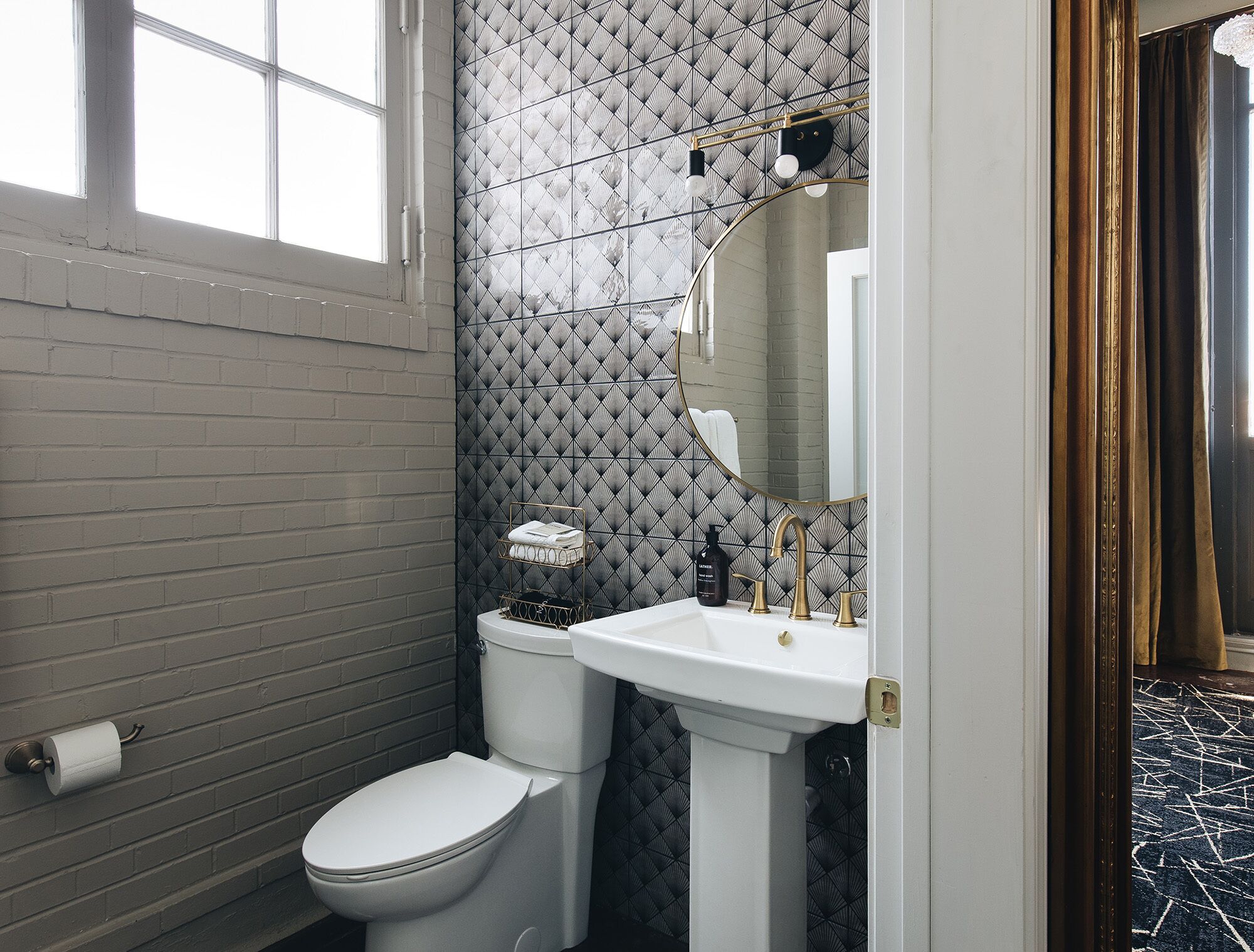 A bathroom with a white toilet, a pedestal sink, and a mirror.