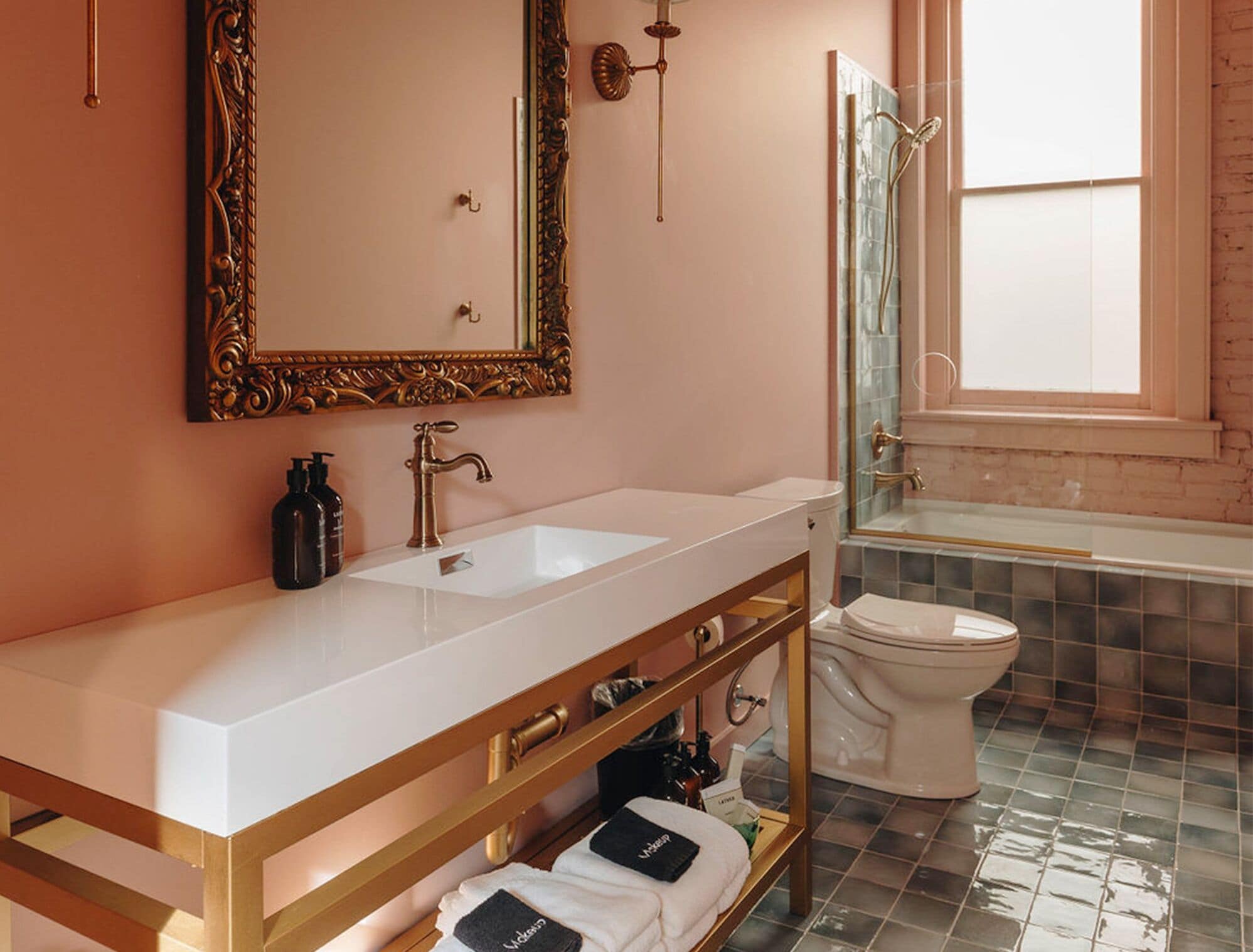A modern bathroom with a large mirror, a sink, and a toilet.