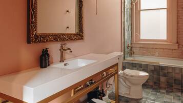 A modern bathroom with a large mirror, a sink, and a toilet.