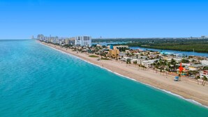 Un paisaje urbano costero con playa, edificios y cielo despejado.