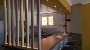 Une cuisine moderne dotée d’un îlot central, d’une fenêtre ornée de vitraux et d’un meuble à vin.