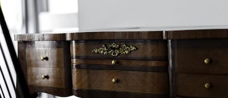 A wooden desk with three drawers and a metal chair.