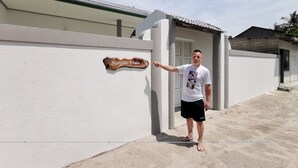Un hombre de pie junto a un edificio con un letrero que dice "Boagas 2018".