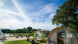 Une structure en bois avec une pancarte indiquant que l’accès au sauna se fait sur réservation.
