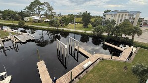 A calm water body with docks, surrounded by greenery and residential buildings. - The Salty Snook in Suwannee, FL BEST LOCATION in Complex with Private Boat Slip! (Suwannee)