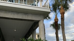 A multi-story building with balconies, palm trees, and a covered walkway. - The Salty Snook in Suwannee, FL BEST LOCATION in Complex with Private Boat Slip! (Suwannee)