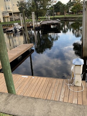Un muelle de madera se extiende sobre aguas tranquilas, con una embarcación amarrada al final.