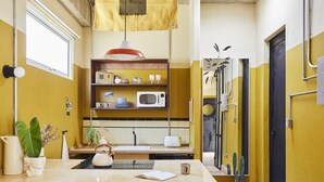 Una cocina con microondas, fregadero y varios utensilios.
