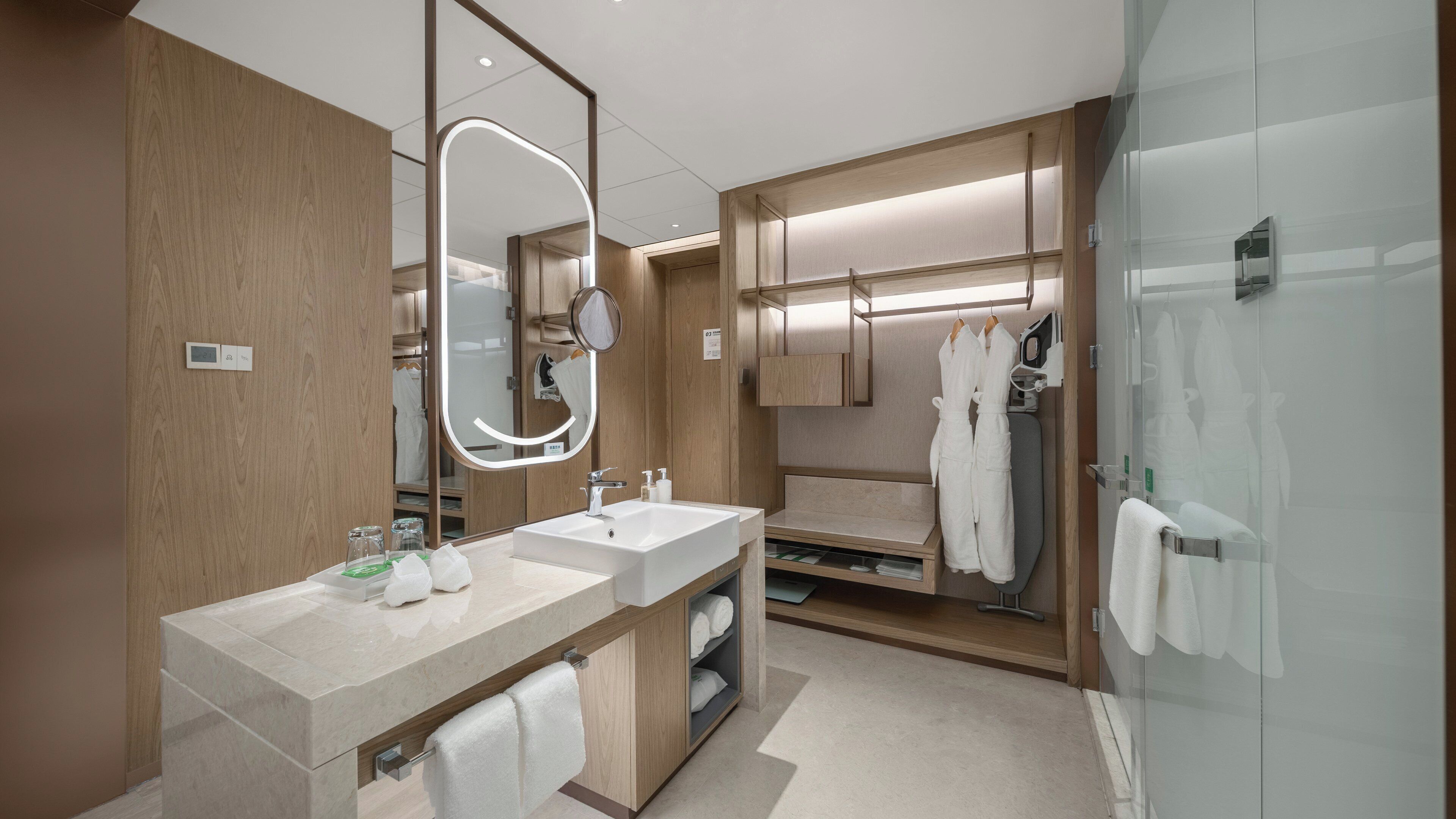 Un baño moderno con dos lavamanos, un espejo grande y una ducha a ras de suelo.